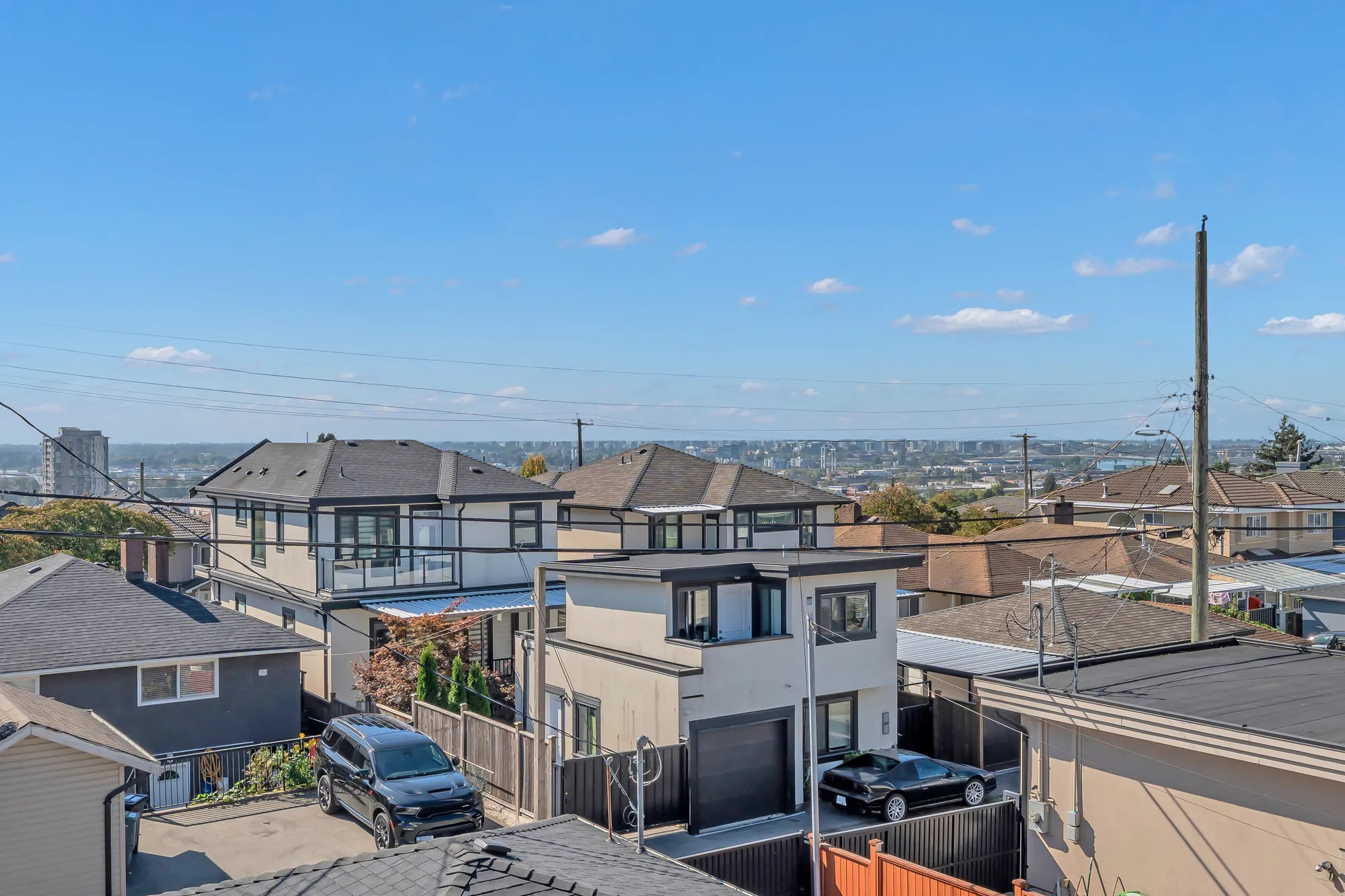 From the upper balcony: the rooftops of the neighbourhood, the lane, and the towers of Richmond on the flat horizon