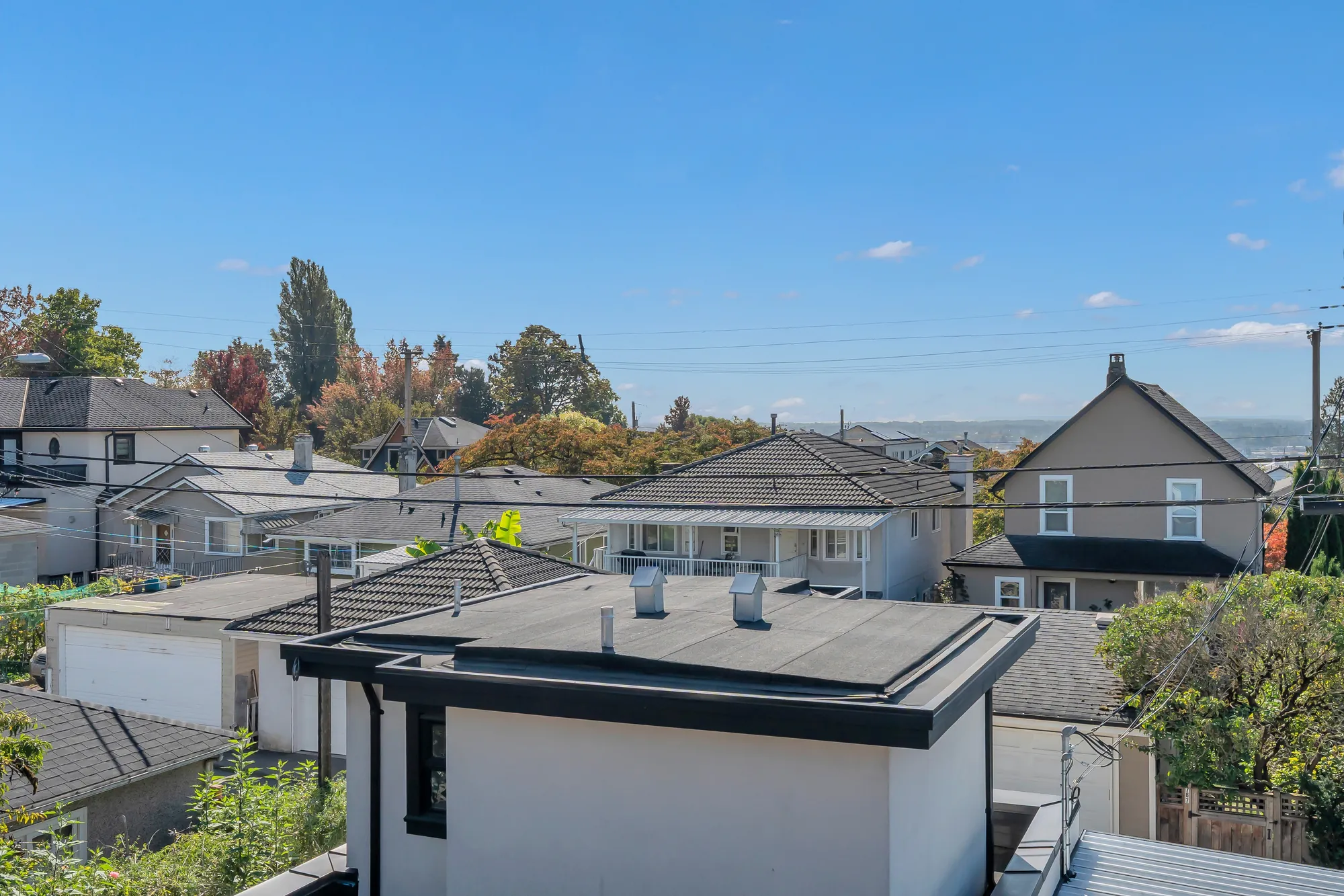 From the upper balcony toward the laneway house's roof, the trees and houses beyond