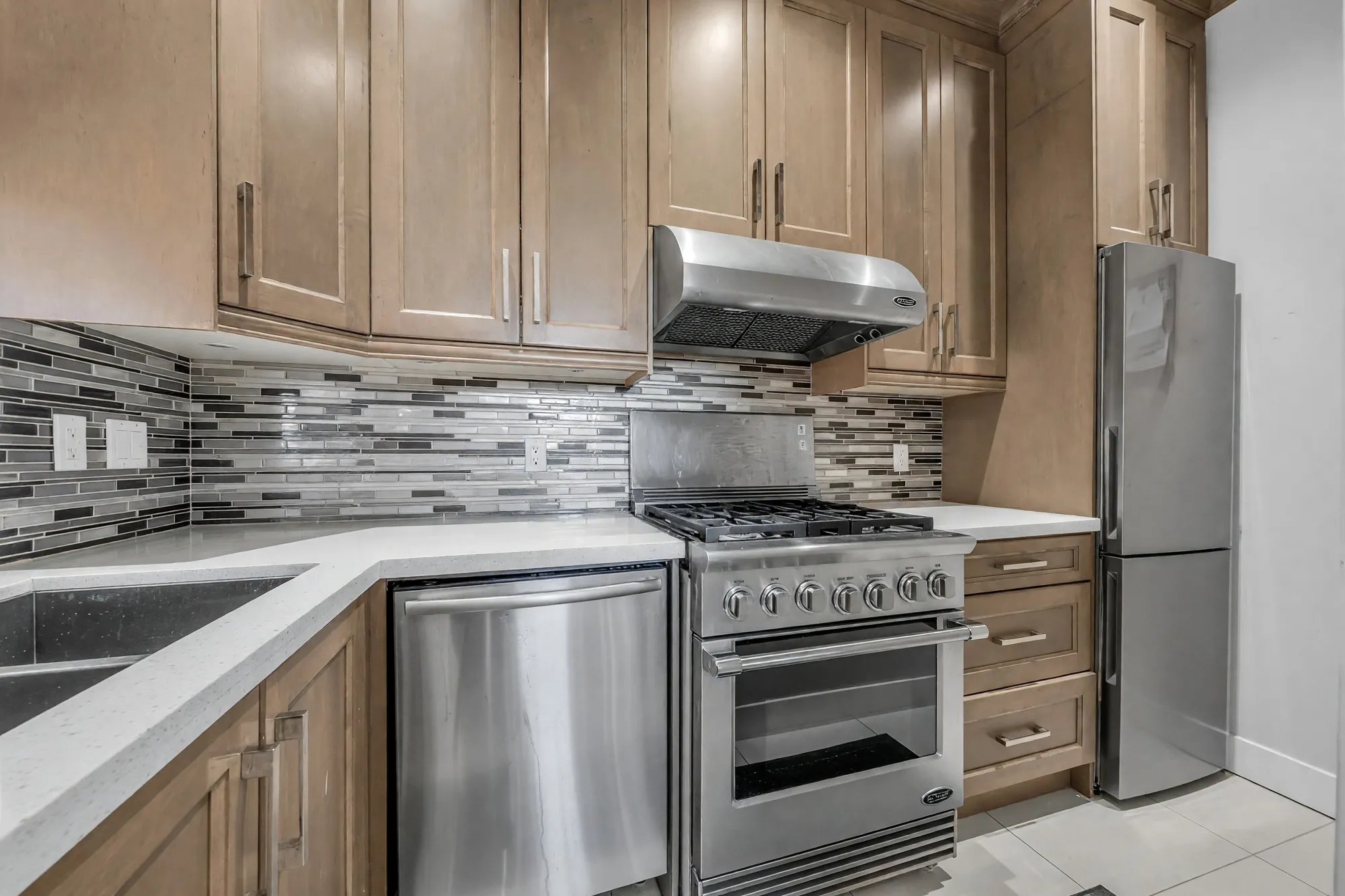 The wok kitchen's range and its second refrigerator, the mosaic backsplash